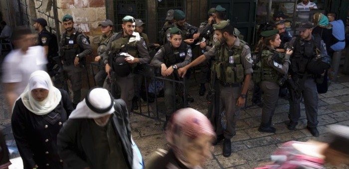 Palestinians walk past Israeli police after Friday prayers outside Damascus Gate in Jerusalem’s Old City