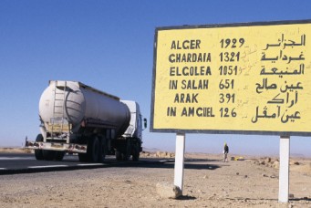 Truck passing road sign in Tamanrasset, Algeria. Frans Lemmens/Corbis